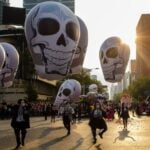 Day of the Dead parade in Mexico City with elaborate skulls.