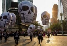 Day of the Dead parade in Mexico City with elaborate skulls.