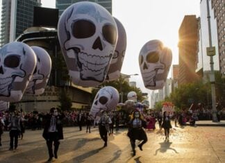 Day of the Dead parade in Mexico City with elaborate skulls.
