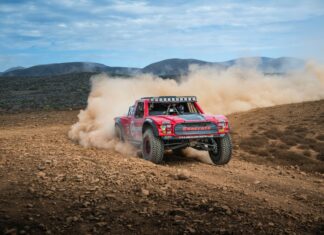Kicking up desert dust as a car goes off-road during the 2025 Baja 1000 race.
