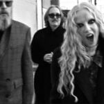 Alt-rock band Garbage - lead singer Shirley Manson screams at the camera, with bandmates in jackets behind her