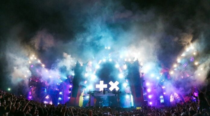 Live music concert experience in Zapopan, with fans holding up rock on signs as they mass in front of the smoky stage