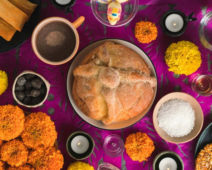 Pan de Muerto on a table with cempasúchil flowers