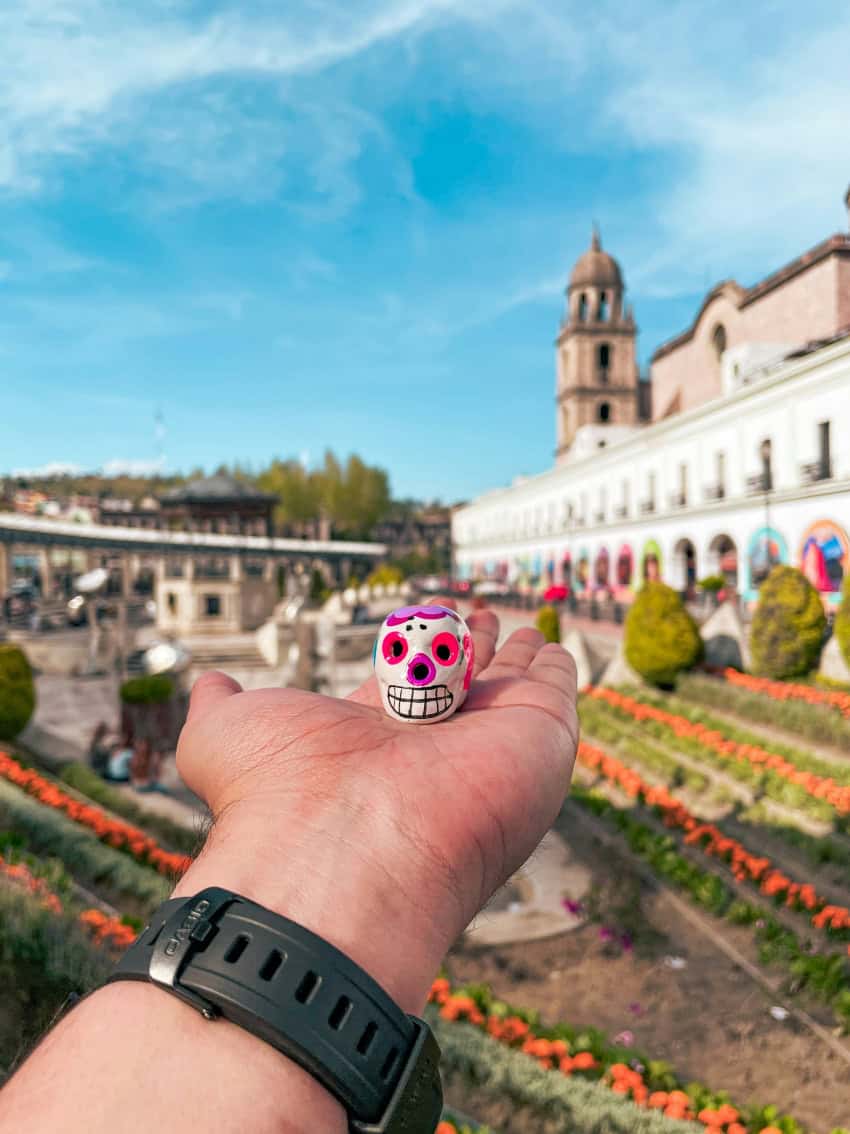 Calavera being held up against the backdrop of Toluca