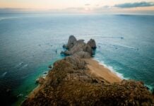 Fishing boats speeding by the Land's End headland in Cabo San Lucas.