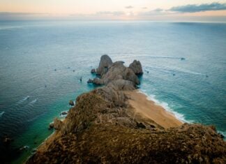 Fishing boats speeding by the Land's End headland in Cabo San Lucas.