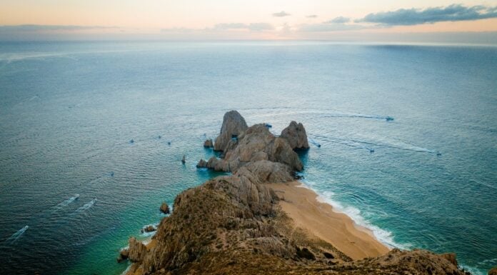 Fishing boats speeding by the Land's End headland in Cabo San Lucas.