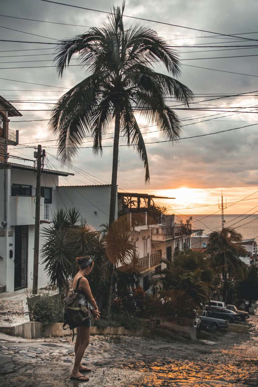 Woman in white tank top staring at the ocean in Puerto Vallarta