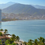 Coastal view of Puerto Vallarta with palm trees, city and mountains in the background