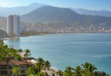 Coastal view of Puerto Vallarta with palm trees, city and mountains in the background