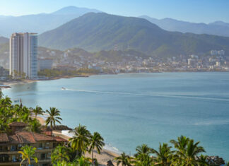 Coastal view of Puerto Vallarta with palm trees, city and mountains in the background