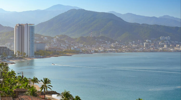 Coastal view of Puerto Vallarta with palm trees, city and mountains in the background