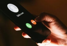 A closeup shows a hand pushing the decline button on an unknown call, on a smartphone