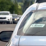 Calgary, Alberta, Canada. Jul 01, 2024. A close up to an Uber sign on a vehicle car on the road.