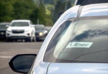 Calgary, Alberta, Canada. Jul 01, 2024. A close up to an Uber sign on a vehicle car on the road.