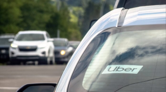 Calgary, Alberta, Canada. Jul 01, 2024. A close up to an Uber sign on a vehicle car on the road.