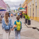 A blond woman and child walk down a colonial Mexican street in San Cristobal de las Casas, Chiapas