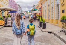 A blond woman and child walk down a colonial Mexican street in San Cristobal de las Casas, Chiapas