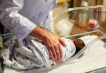 A doctor checks on a newborn in the NICU
