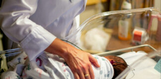 A doctor checks on a newborn in the NICU